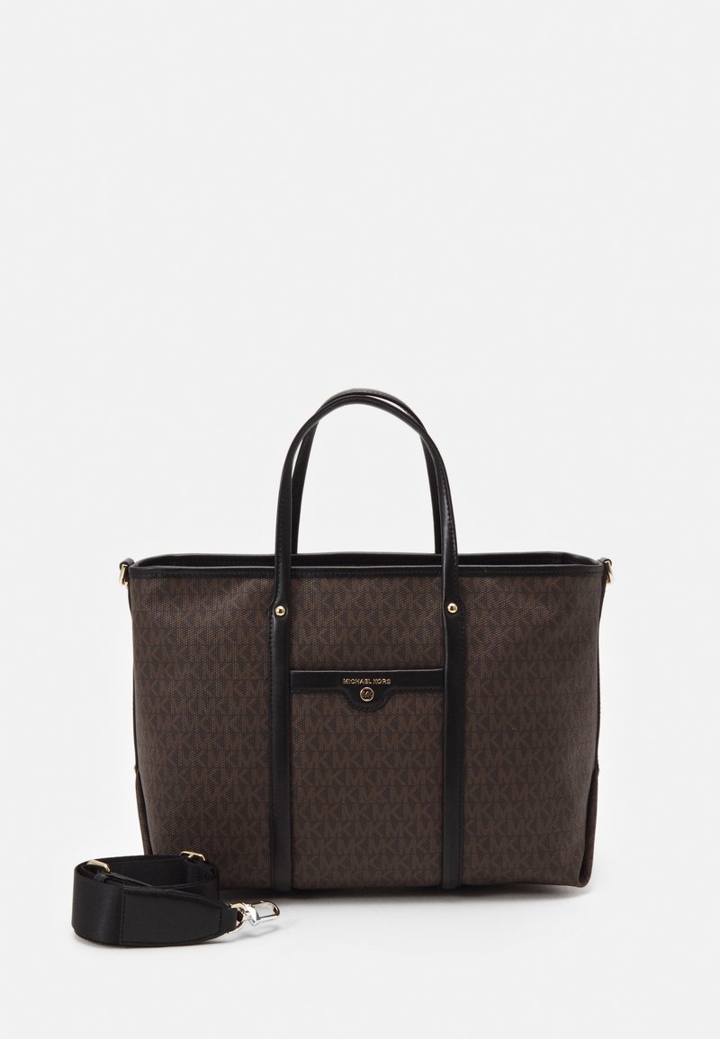 Sac cabas marron Michael Kors avec poignées noires, poche avant et bandoulière amovible sur fond blanc.