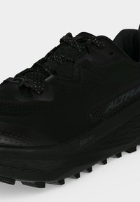 Chaussure de trail noire avec semelle texturée, lacets à motifs et marquage visible "Egomax" et "Altra" sur le côté.