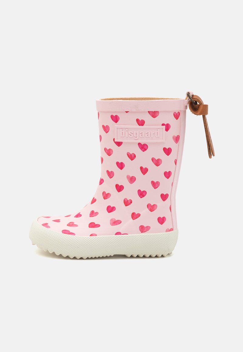 Botte en caoutchouc rose dotée d'une semelle blanche, décorée d'un motif de cœurs rouges, et d'une languette en cuir marron à l'arrière.