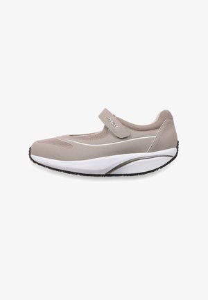 Zapatilla estilo Mary Jane beige claro con parte superior de malla, correa ajustable con la etiqueta "MBT", suela blanca gruesa y suela exterior negra con dibujo.
