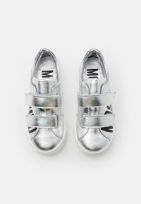 Sneaker metallici argento con due cinturini in Velcro, punta arrotondata, suola in gomma bianca e un dettaglio con logo nero sul lato.