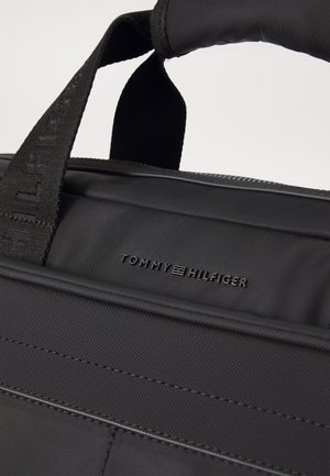 Czarna torba Tommy Hilfiger z wyściełanym uchwytem i teksturowanym detalem materiału na przedniej kieszeni.