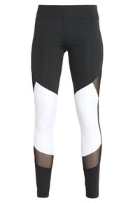 Leggings atléticos en blanco y negro con cintura alta, diseño geométrico de bloques de color, paneles de malla transparentes y una forma ajustada.