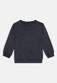 Mørkegrå hettegenser med rund hals, lange ermer og ribbede mansjetter og nederkant. Materialet har en myk, jevn tekstur.