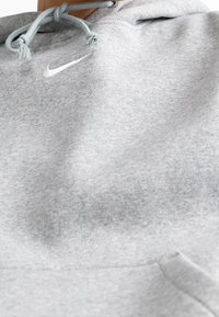 Grå bomullshuvtröja med en liten vit Nike-logotyp, justerbara blå snoddar och en framficka med en subtil textur.