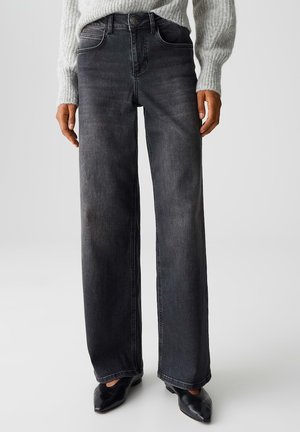 Jeans in denim nero a vita alta con design a gamba larga, tasche anteriori e dettagli di cucitura sottili. Texture liscia e taglio classico.