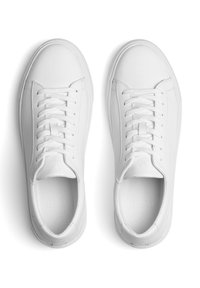 Hvide lædersneakers med en glat overflade, der har en rund tå, seks snorlufthuller og flade snørebånd. Minimalistisk design uden synlige logoer.