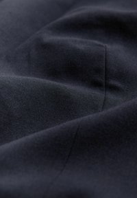 Dark fabric with a smooth texture, featuring subtle folds and a matte finish. The color is consistent throughout, with no visible patterns or accents.