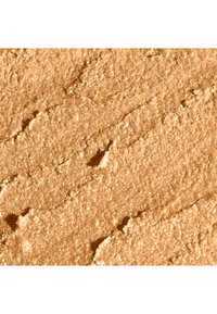 Locker gepresstes Puder in einem warmen, goldbraunen Ton mit feinem Schimmer. Die Oberflächenstruktur ist leicht uneben mit sichtbaren Rillen und körnigen Details.