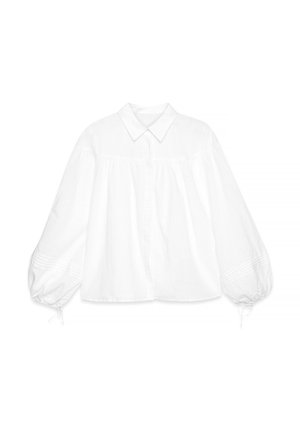 Bela bombažna bluzica z gumbnim zapenjanjem na sprednji strani, ovratnikom in obsežnimi balonastimi rokavi. Ima subtilne teksturirane detajle na manšetah.