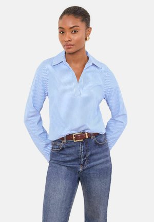 Blau-weiß gestreiftes Hemd mit langen Ärmeln und Kragen, kombiniert mit dunkelblauer Jeans und braunem Gürtel. Glatte Stoffstruktur.