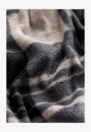 Mäkká, textúrovaná deka s čiernym, šedým a béžovým abstraktným vzorom, so zobrazenými záhybmi a hebkým povrchom.