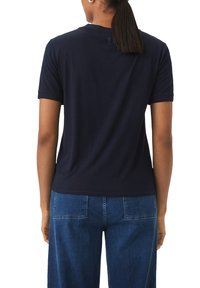 Marineblaue Kurzarm-T-Shirt mit Rundhalsausschnitt, leicht elastisch und mit einer glatten Textur. Auf der Rückseite befindet sich ein kleines Logodesign.