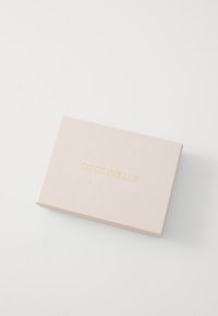 Scatola rettangolare rosa con superficie liscia, caratterizzata dal logo in oro embossato "COCCINELLE" sulla parte anteriore. Design chiuso, stile minimalista.