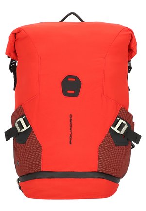 Zaino rosso a chiusura roll-top con dettagli neri, dotato di cinghie laterali regolabili, dettagli in rete e manico superiore per il trasporto.