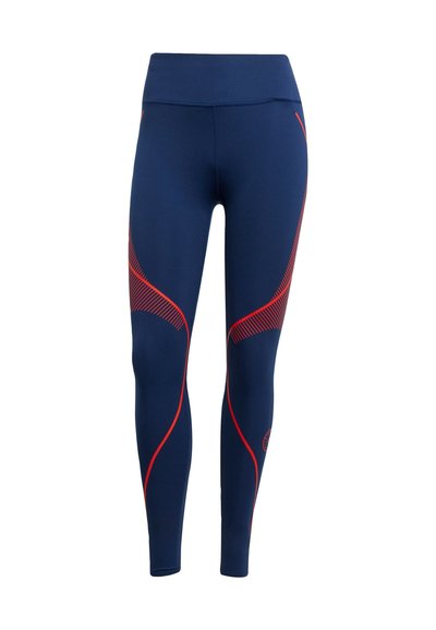 Navy urheiluleggingsit punaisilla kaarevilla yksityiskohdilla ja teksturoidulla kuviolla. Sisältää korkean vyötärön ja sulavalinjaisen, vartalonmyötäisen muotoilun.