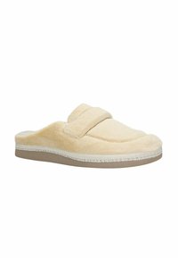 Beige fleece pantoffel met een zachte textuur, plat ontwerp en een klittenbandsluiting. Beschikt over een ronde neus en een rubberachtige zool.
