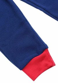 Bras de tissu en polaire bleu avec un poignet côtelé rouge. La surface semble douce et texturée, indiquant chaleur et confort.