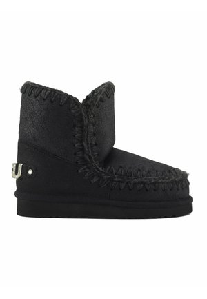 Stivale alla caviglia in suede nero con una finitura testurizzata, dettagli cuciti, profilo basso e un accento metallico decorativo sul lato.