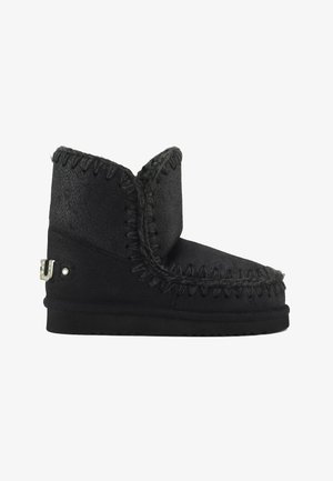 Stivale alla caviglia in suede nero con una finitura testurizzata, dettagli cuciti, profilo basso e un accento metallico decorativo sul lato.