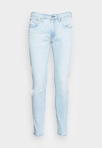 Jasnoniebieskie dżinsy, slim fit, z przetarciem na kolanie, pięć kieszeni, metalowy zamek błyskawiczny. Standardowy pas, bez ozdób.