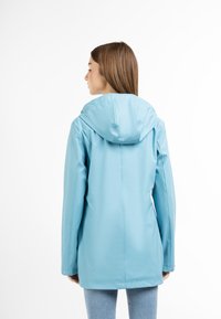 Ljust blå vattentät jacka med huva, med en slät textur och rak passform. Ingen synlig hårdvara eller mönster.