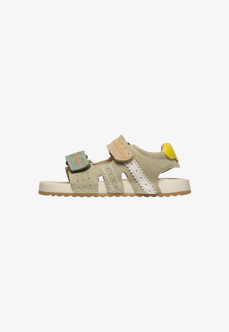 Sandale en daim beige pour enfant avec des brides en Velcro vertes et marron clair, détails de couture blancs, languette de talon jaune, et semelle beige à motif texturé.