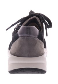 Zwarte en grijze suède sneaker met een gewatteerde kraag, platte veters en een contrasterende witte zool. Heeft een rits aan de zijkant.