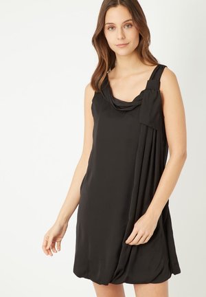 Vestido negro sin mangas hecho de una tela suave, con escote drapeado, detalles plisados en un lado y un corte relajado.