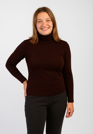 Maglione a collo alto marrone realizzato in un tessuto liscio e elasticizzato, con maniche lunghe e una silhouette aderente, abbinato a pantaloni grigio scuro.