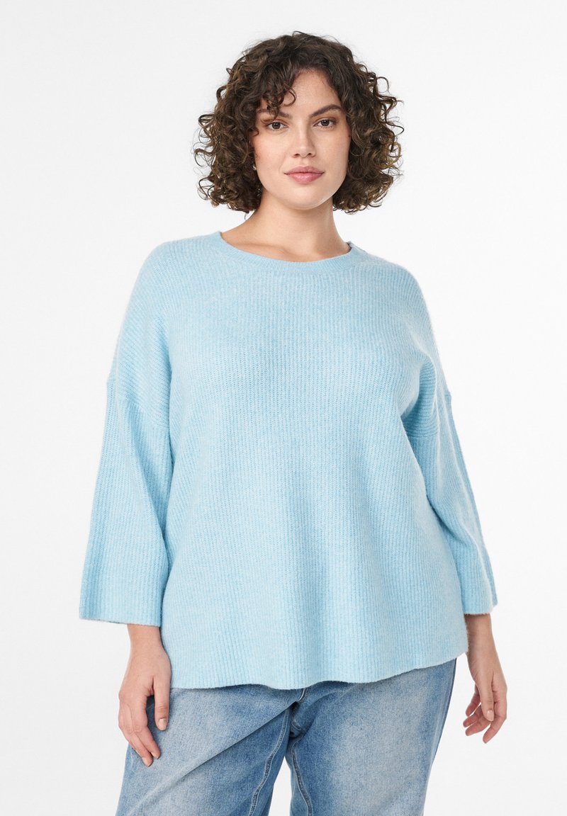 Maglione a coste di un blu chiaro, con maniche larghe a tre quarti e scollatura rotonda. Tessuto morbido, vestibilità rilassata e arriva all'altezza dell'anca.