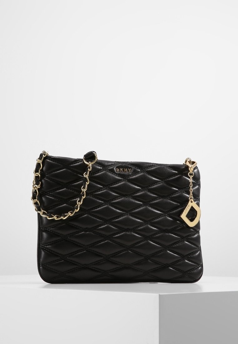 Borsa a tracolla nera trapuntata con catena dorata e un accento decorativo a forma di portachiavi. Presenta un motivo a diamante e un dettaglio del logo sul davanti.