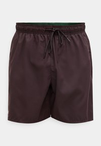 Shorts de bain marron avec une ceinture élastique, un cordon de serrage ajustable et une doublure intérieure verte. Fabriqués en matière légère et lisse.