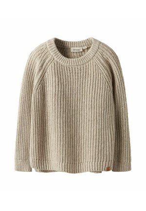 Pull en tricot beige avec une texture côtelée, col rond et manches raglan. Présente une petite étiquette en cuir de la marque sur le bas gauche.