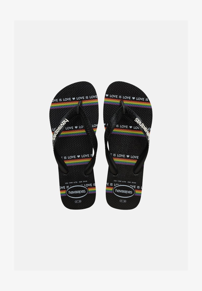 Μαύρα σαγιονάρες με υφή στη σόλα, διακοσμημένες με ρίγες ουράνιου τόξου και επαναλαμβανόμενο κείμενο "LOVE IS LOVE", λευκό λογότυπο Havaianas στα λουράκια και τη σόλα.