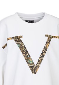 Witte sweatshirt met een groot zwart en gouden patroon van een "V" ontwerp aan de voorkant. De stof heeft een gladde, zachte textuur.