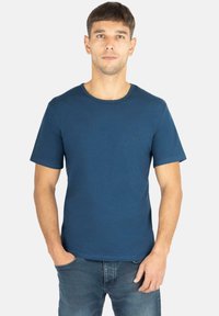 Blaues T-Shirt mit kurzen Ärmeln aus Baumwolle, mit rundem Ausschnitt und kleinem Logo auf der Brust. Glatte Textur, normale Passform.