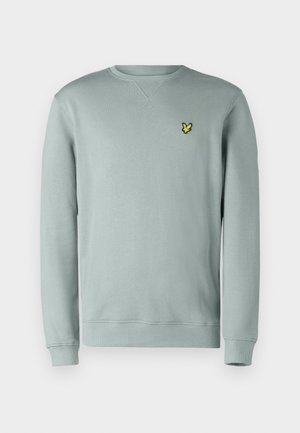 Ljusgrå sweatshirt med långa ärmar och ribbad rundad halsringning. Har en liten gul broderad logotyp på vänster bröst.
