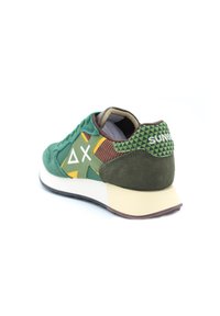 Zelené semišové tenisky s žlutými a hnědými akcenty, patou s trojúhelníkovým vzorem, bílým logem a polstrovanou podrážkou.