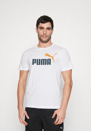 T-shirt in cotone bianco con un grande logo nero "PUMA" e un'immagine di un puma arancione in salto, scollo rotondo e maniche corte.