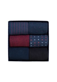 Zes paren gevouwen herensokken in navy, zwart en rood met verschillende gestreepte en gestipte patronen in een donkerblauwe doos.