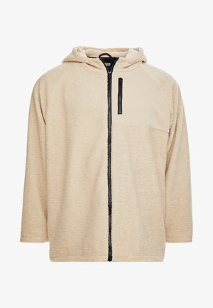 Kerge lõngaga kapuutsiga jope, millel on tõmblukk ees, struktuurne pind ja ühtlane beež paneel rinnal. Omab musta tõmblukku ja aksessuaare.