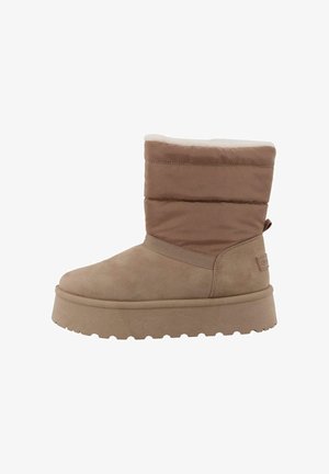 Ruske nubuck ankle bootta on paksu pohja, pehmustettu yläosa ja pehmeä, teksturoitu resori. Sisältää minimalistisen muotoilun sivulogolla.