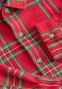 Rotes Flanellhemd mit einem Karomuster in Grün, Gelb und Weiß. Verfügt über Knopfverschlüsse und eine weiche Textur.