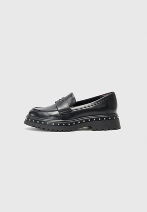 Mocasines de cuero negro con una correa ancha y suela de plataforma con tachuelas, presentan una textura suave y un diseño de puntera redondeada.