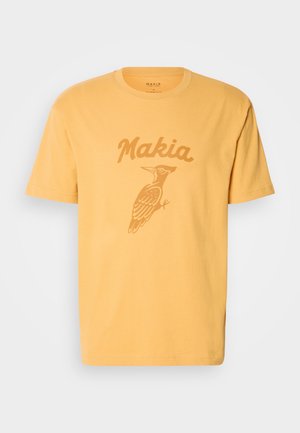 Kollane puuvillane T-särk, millel on peitspuuli graafika ja kontrastse varjundiga tekst "Makia". Lühikesed varrukad ja ümar kaelus.