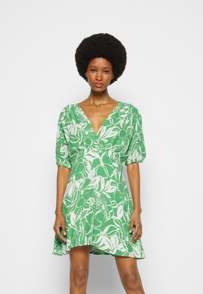 Vestido floral com um design em verde e branco, decote em V, mangas curtas bufantes e barra rodada, feito de tecido leve.
