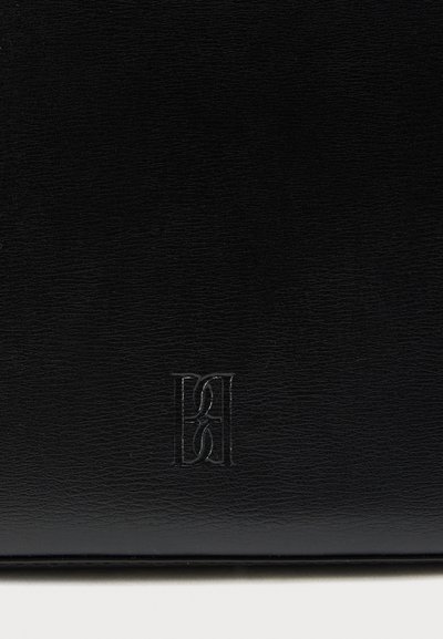 Μαύρη δερμάτινη τσάντα με υφή στην επιφάνεια και ανάγλυφο λογότυπο. Διαθέτει κομψό ορθογώνιο σχήμα και μίνιμαλ σχεδιασμό.