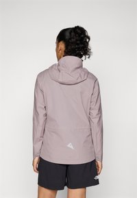 Veste légère de couleur violet pâle avec capuche, dotée d'un motif géométrique réfléchissant à l'arrière, de manches longues et d'un design respirant.