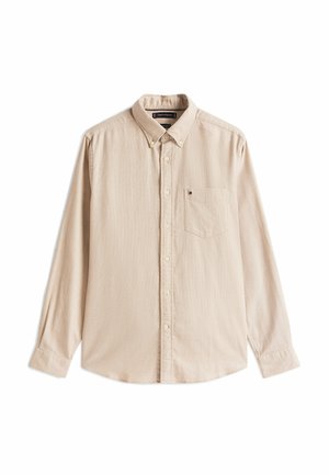 Camicia beige a maniche lunghe in un tessuto morbido con colletto a bottoni, dotata di taschino sul petto e dettagli di texture discreti.